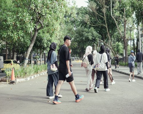 Group of people taking a casual walk in a Malaysian city park